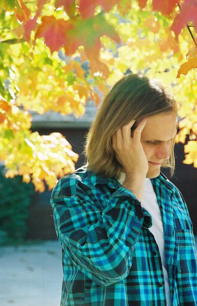 Picture of Matthew Hope behind fall leaves